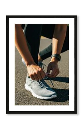 Athlete tying running shoes outdoors for fitness and exercise motivation