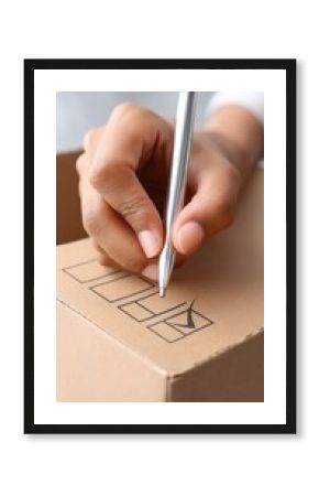 Fitness motivation routine transformation concept. A person checks off a box on a cardboard package with a silver pen.