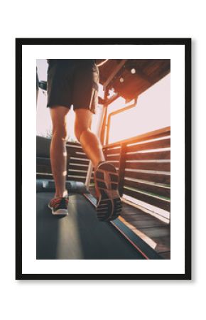 The guy jogging on treadmill on terrace of his home. Social isolation or quarantine concept