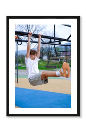 Young Man Doing Hanging Leg Raise Workout Outdoors. Athletic man performs hanging leg raises on an outdoor fitness bar