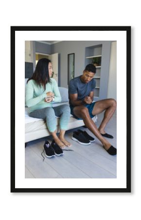 Couple preparing for morning workout, putting on shoes in bedroom