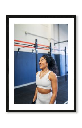 Young Latina walking and smiling at the gym