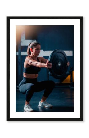 Exercising with weights, a woman places weights on a barbell, preparing for training to build strength in a focused gym setting.