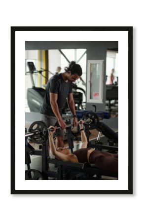 Young Trainer Spotting Woman During Bench Press