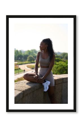 Young sporty woman relaxing after training outdoors in a park