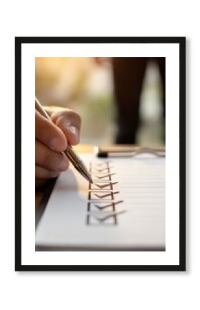 Person crossing off goals on checklist, natural light, accomplishment and motivation concept