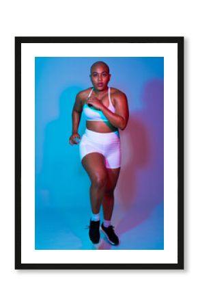 Bald athlete in sportswear running indoors with determination