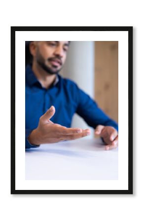Gesturing while discussing work, businessman at office meeting table