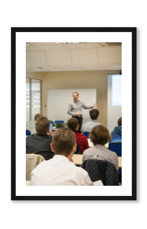 presenter near the screen and people sitting rear
