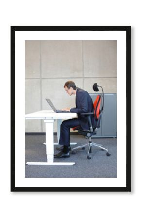 short-sighted business man bad sitting posture at laptop .
