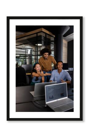 Asian woman and colleagues discussing project on computer in modern office
