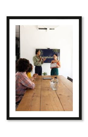 Receiving certificate during office meeting, woman getting applause from colleagues