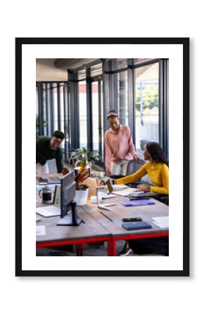Collaborating in modern office, diverse team discussing project around table