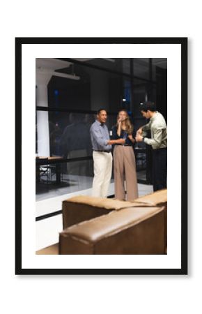 Colleagues in office enjoying drinks and conversation during evening gathering