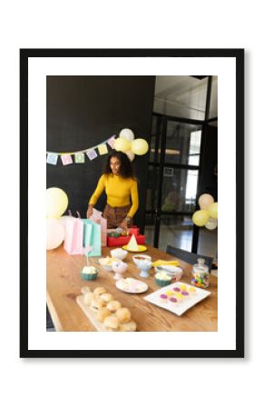 Woman preparing party table with snacks and gifts in office celebration