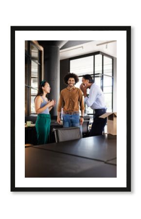 Sharing laugh during casual conversation, diverse colleagues in modern office setting