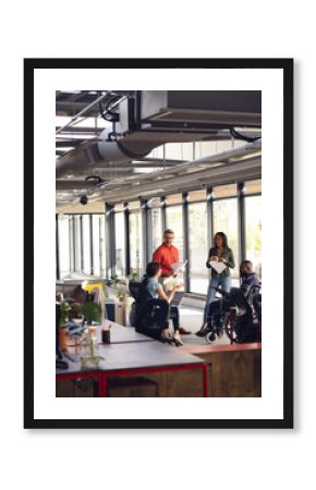 Diverse business people having meeting, discussing work and using laptop and tablet at office