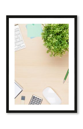 Office table with notepad, computer and flower