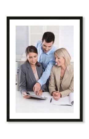 Erfolgreiches Business Team blickt auf einen Tablet PC