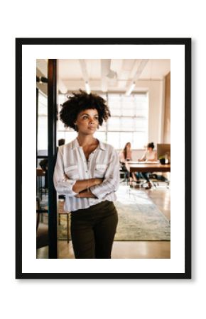Thoughtful woman at office doorway and looking away