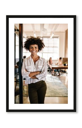 Smiling young woman leaning to office doorway