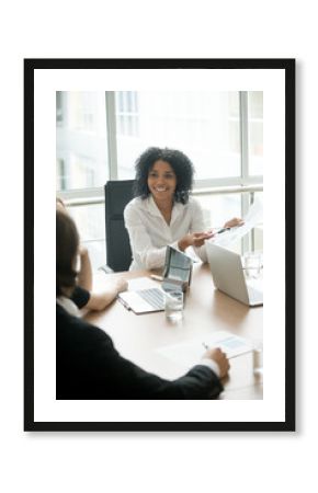 Smiling african businesswoman executive sharing good news meeting partners showing project report, forecasting profit increase, promising benefits satisfied with work result and growth, vertical view