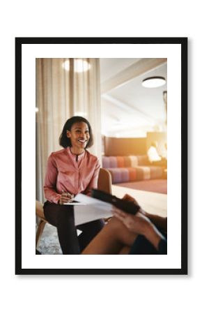 Smiling young businesswoman sitting with an office colleague dis