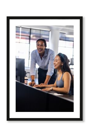 Colleagues collaborating on computer in modern office, sharing ideas and solutions