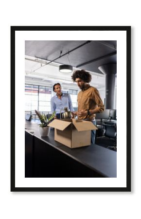 Colleagues unpacking box in modern office, discussing new project ideas