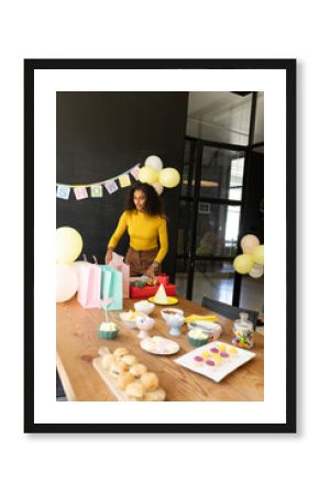 Woman preparing party table with snacks and gifts in office celebration