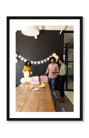 Colleagues preparing for office celebration with balloons and gift bags