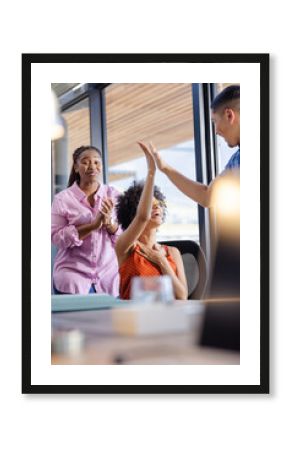 In office, diverse colleagues high-fiving, celebrating success and feeling accomplished