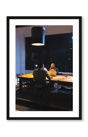 Business professionals discussing project at night meeting in modern office