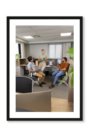 Gathering Diverse coworkers chatting and sipping coffee in open-plan office, with tablet and plants