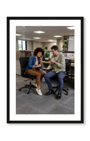 Analyzing data diverse colleagues working in open-plan office, using tablet and monitors