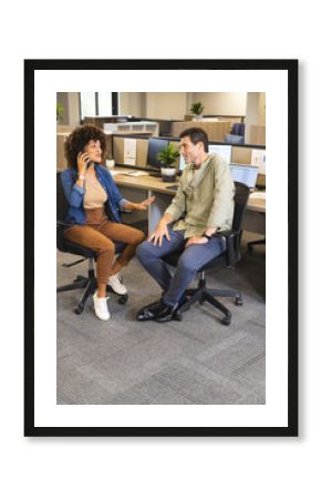 Collaborating Diverse coworkers analyzing charts on monitors in office space, with smartphones
