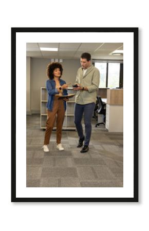 Collaborating Diverse coworkers exchanging ideas in open-plan office, with notebook and smartphone