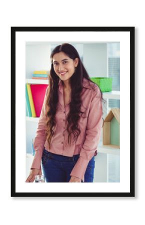 Smiling businesswoman standing confidently in modern office with colorful decor