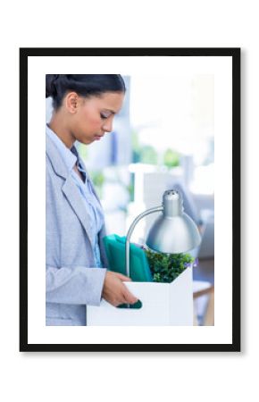 Businesswoman carrying office items in box, leaving workplace with determination