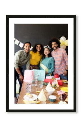 Diverse group celebrating at party with gifts and decorations, smiling together, at office