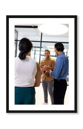 Diverse business team discussing ideas in modern office, smiling and engaged
