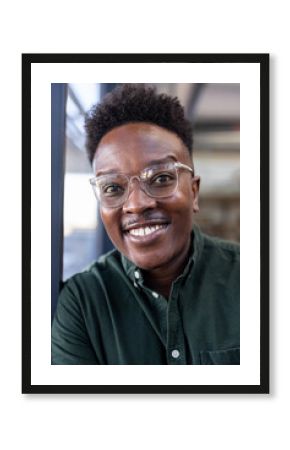 Smiling professional wearing glasses in office, exuding confidence and positivity