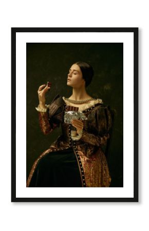 Portrait of a girl wearing a princess or countess dress over dark studio. portrait with sweet chocolate bar over dark studio