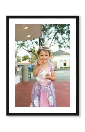 little girl eats ice cream in princess costume