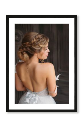 charming tender princess stands with her back to camera, soft features with professional make-up, magnificent white amazing dress with open back and shoulders for prom high school graduation 2019