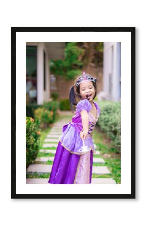 Portrait of cute smiling little girl in princess costume standing on the footpath
