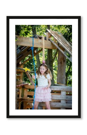 Girl dressed as a princess with crown and sceptre playing in a tree house