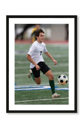 Athletic young boy playing in a competitive soccer game