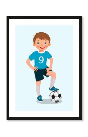 Portrait of cute little boy in sportswear with a soccer ball posing with hand on the waist