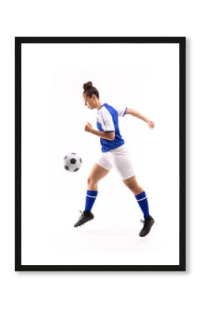Side view of biracial young female player in mid-air kicking ball while playing soccer